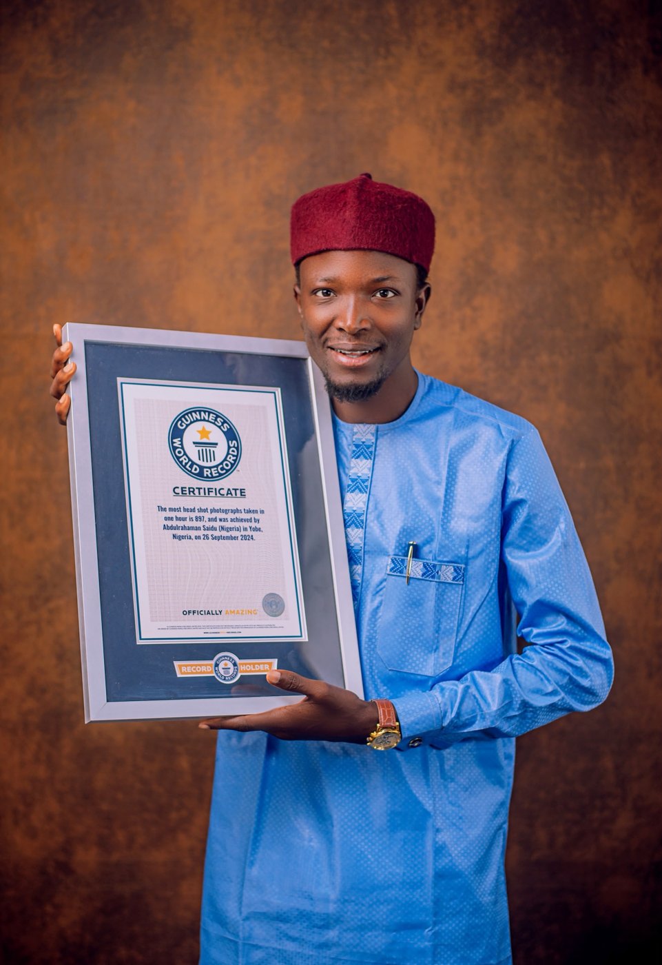 Saidu Abdurrahman in studio with his certificate